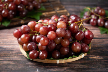 sweet red grapes on wooden table.