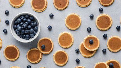 Flat lay of mini pancakes with blueberries on muted grey