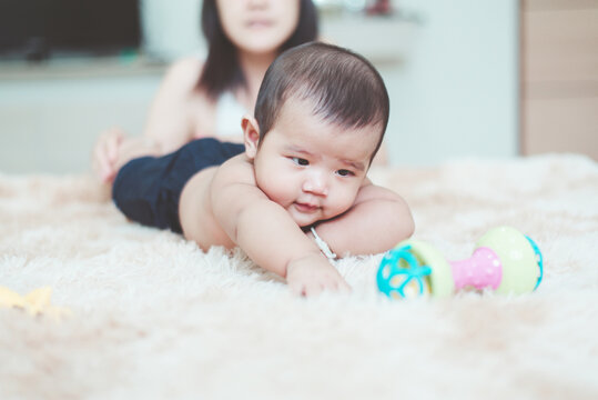 Happy adorable asian baby boy relaxing with mom on bed,Newborn child,Tummy Time