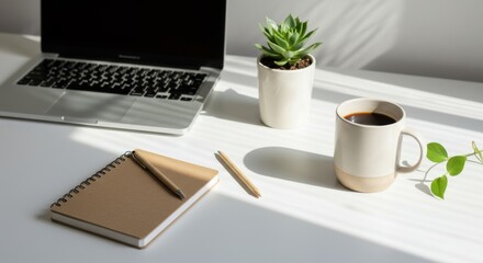 A productive work-from-home setup featuring a laptop, coffee, succulent, and notebook on a sunlit desk