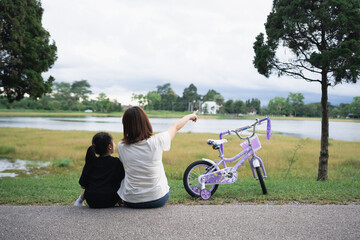 Mother and Daughter Enjoying Scenic View by the Lake with Bicycle, Family Bonding, Outdoor...