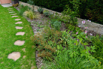 Obraz premium Magnifique jardin fleuri et verdoyant niché au cœur de la campagne, offrant un paysage paisible et coloré.