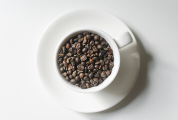 Green coffee beans in a small white coffee cup on the table. Alternative drink concept. Selective...