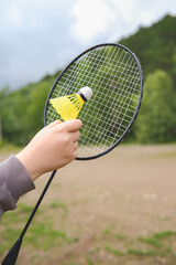 A Child Holding a Badminton Racket and Shuttlecock While Enjoying Outdoor Activities