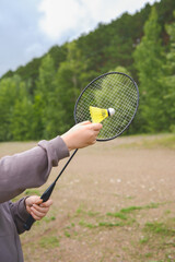 A Child Holding a Badminton Racket and Shuttlecock While Enjoying Outdoor Activities