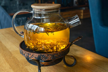 Golden hour tea ritual featuring herbal tea in a glass teapot symbolizing harmony warmth and shared moments of joy. Tranquil tea moment with herbal infusion in a clear teapot surrounded.