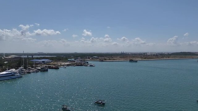 Scenic View of Bali Island from Benoa Port with Docked Yachts and Vehicles Moving on Toll Road