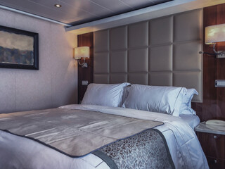 Luxurious suite stateroom cabin room onboard luxury all inclusive yacht cruise ship cruiseship liner with bedroom and living area in turquoise and creme with wood in modern Art Deco interior design
