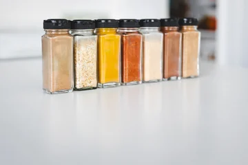 organised tidy spice jars on kitchen countertop featuring pantry staples and different flavours for home cooking © faithie