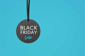 Black friday sale word on price tag on blue background