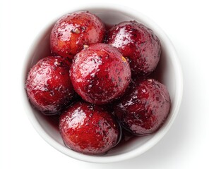 Small bowl of plump, glistening, dark-red fruit, glazed