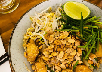 Stir-fried dry noodles (Kuay Teow Klook Khew) tossed with savory sauce, fresh vegetables, and your choice of meat — a flavorful Thai street food classic.