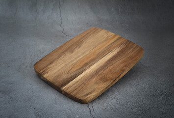 Wooden empty cutting board on dark grey background, food advertisement display, showcase.