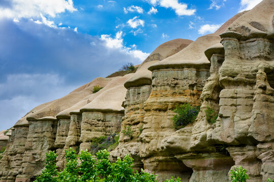 Fairy chimneys rising from Cappadocia landscape under cloudy sky