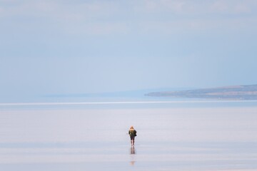 Musician walking in Tuz Lake, Turkey, carrying guitar