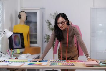 Fashion designer choosing colors for new clothes collection in design studio
