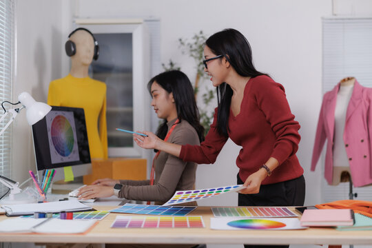 Fashion designers choosing colors for new clothes collection using color palettes and computer software - Powered by Adobe