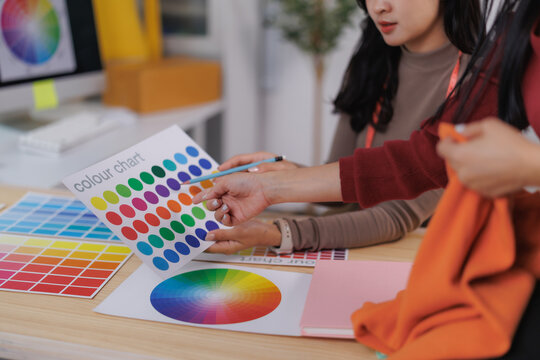 Fashion designers discussing color palette for new clothes collection