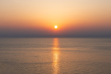 clean seascape with calm sea water surface under soft sunset sky and sun reflection. sea under...