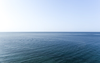 calm sea under clear light blue sky. waterline. sea water surface. minimalist seascape with copy...