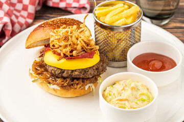 Delicious gourmet burger with cheddar cheese, fried onions, coleslaw and fries