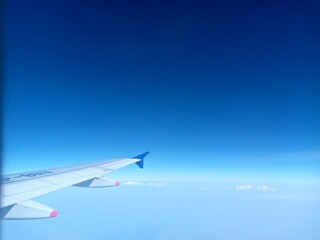 airplane wing against the beautiful blue sky showing a clean horizon with gradient sky