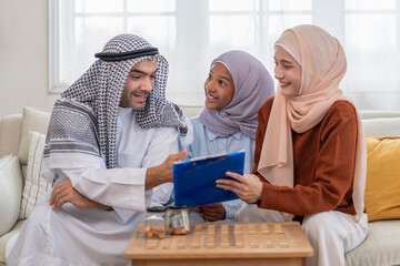 An islam teenage girl excited on earnings while young muslim married couple help kid doing savings...