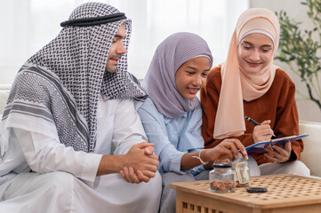 Islam teenage girl counts money,young muslim married couple help kid doing savings plan,concept...