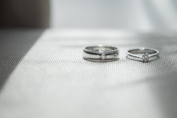 couple of wedding rings stacking on the bed in bedroom of honeymoon sweet time