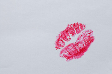 Bright lip imprint with red lipstick on white paper, symbol of kiss and romance, love and message