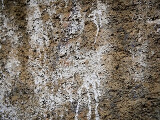 Close up of the rough texture of an old cement wall painted with spray paint.
