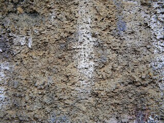 Close up of the rough texture of an old cement wall painted with spray paint.