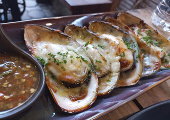 Baked mussels topped with melted cheese, golden and savory, combining fresh seafood flavor with creamy richness — a delicious appetizer or seafood treat.