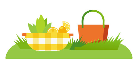 Picnic basket with fruit and oranges on green grass lemons