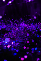 Abstract lights and bokeh form of purple fiber optics glow in a surreal night field