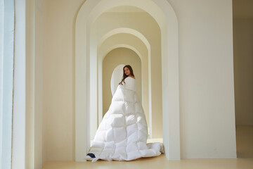 Young woman in white puffy attire in unique archway setting.