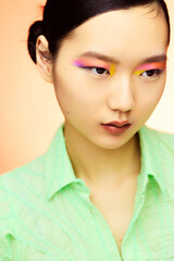 Asian female model with colorful makeup close-up.