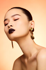Elegant portrait of a young Asian woman with bold makeup.