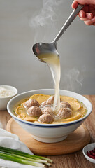 Bakso kuah (soup) being poured into a bowl in slow-motion style, steam rising, ultra-realistic detail