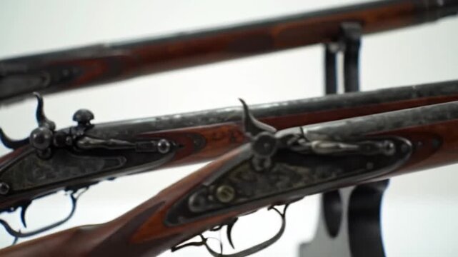 Two classic long rifles with wooden stocks and antique firing mechanisms on display.