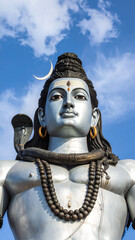Majestic Lord Shiva statue with divine ornaments and cosmic energy depicted against vibrant blue sky and peaceful expression