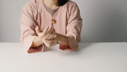 Asian business woman massaging wrist in pain Caused by working on a computer keyboard for a long...