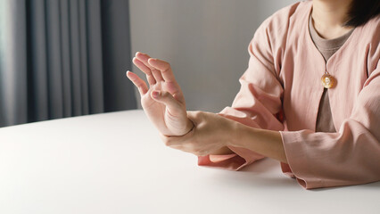 Asian business woman massaging wrist in pain Caused by working on a computer keyboard for a long...