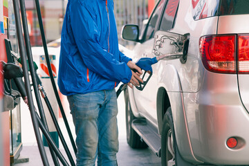 Closeup gas station staff worker hand holding fuel nozzle for refill car fuel, Petroleum business