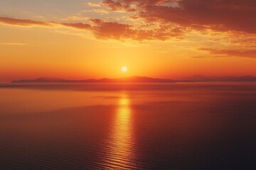 Naklejka premium Aerial view of a vivid orange sunset casting warm light over the calm sea, with glowing reflections on the water surface and a tranquil horizon, capturing the serene beauty of nature from above