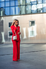vertical Businesswoman commuting to office talking on phone wearing red suit