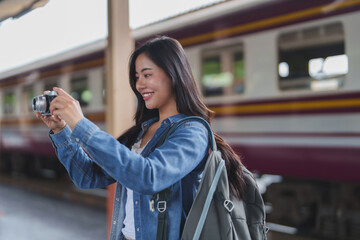 Young woman tourist taking pictures at train station