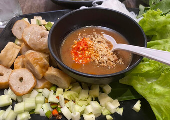 Vietnamese grilled pork skewers (Nem Nuong) served with fresh herbs and spicy dipping sauce, showcasing vibrant street food culture and authentic flavors.