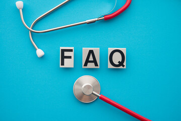 Flay lay FAQ text and stethoscope on blue background. Frequently asked questions (FAQ) in medical,...