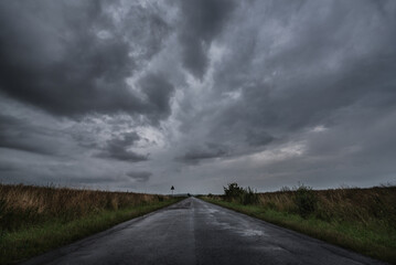 
WEATHER - Dramatic black rain clouds over fields and country road